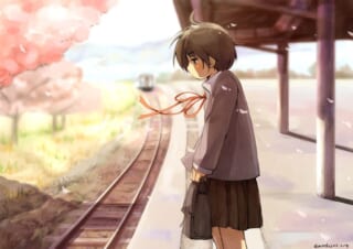 春の駅で電車を待つ女子生徒